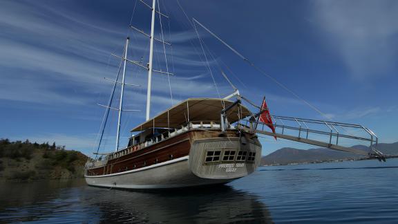 Die Gulet Prenses Selin liegt ruhig im Wasser vor einer Berglandschaft in Fethiye.