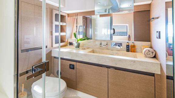 The bathroom of Blue M yacht in Mallorca includes a shower cabin, sink and storage.