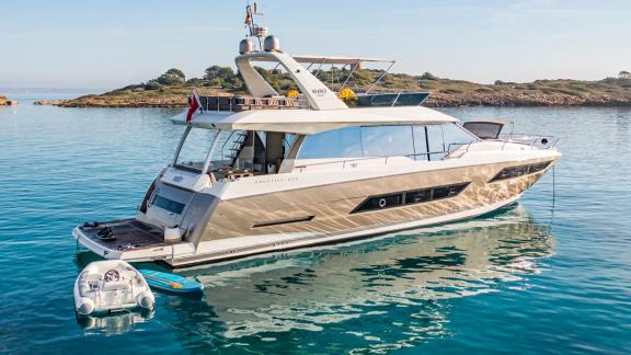 Blue M motor yacht is anchored in calm waters off the coast of Mallorca.