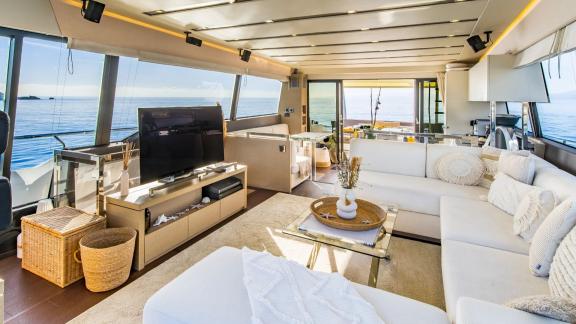 The salon of Blue M motor yacht in Mallorca includes a large seating area and TV.