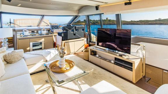 The salon of Blue M motor yacht in Mallorca includes a large seating area and TV.