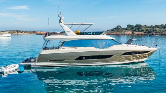 Blue M motor yacht is anchored in calm sea off the coast of Mallorca.