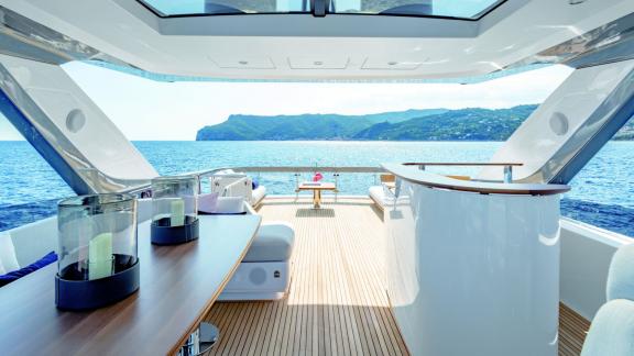 Modern yacht interior with panoramic view of the open sea and coast.