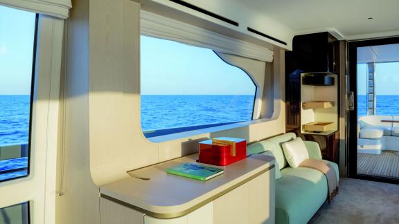 Cozy living area on the yacht with a large window and breathtaking sea view.