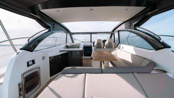 Among Monaco daily yacht charter options Belle Vie motor yacht shows deck with seating and table for relaxation.