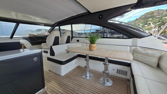 Among Monaco daily yacht charter options Belle Vie motor yacht shows deck with cozy seating and table area.