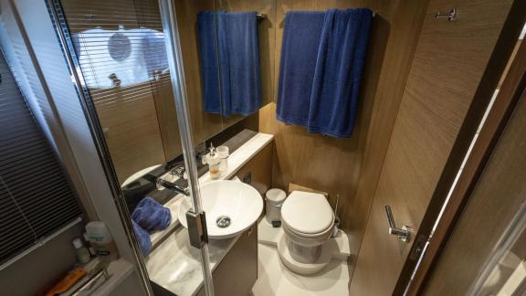 Among Monaco daily yacht charter options Belle Vie motor yacht shows bathroom with compact shower and toilet.