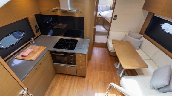 Among Monaco daily yacht charter options Belle Vie motor yacht shows interior with kitchen and dining seating space.