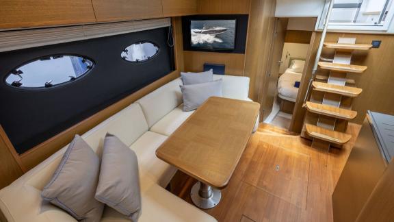 Among Monaco daily yacht charter options Belle Vie motor yacht shows interior with seating and table for comfort.