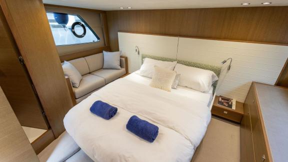 Among Monaco daily yacht charter options Belle Vie motor yacht shows cabin with bed and side seating area.