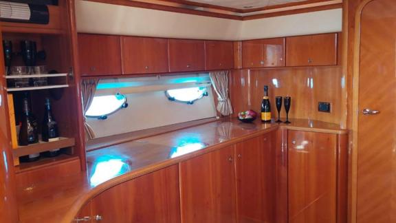 Die Motoryacht Este 2 verfügt über eine Bar mit glänzendem Holz, Sekt und Früchten.