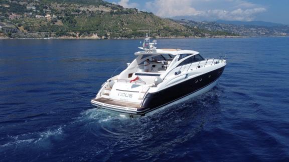Among Monaco yacht rental options Nous motor yacht is seen from rear cruising smoothly on open sea.