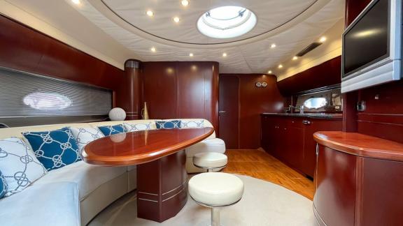 Among Monaco daily yacht charter options Nous motor yacht shows interior with dining table and seating area.