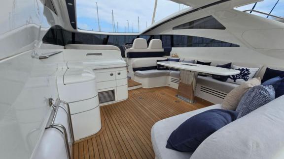 Among Monaco daily yacht charter options Nous motor yacht shows cockpit with comfortable seating and table.