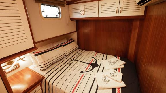 Among Fethiye yacht rental options Queen Alin cabin shows double bed with overhead storage and cozy interior.