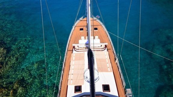 Aerial view of the foredeck of the Queen Lila, stretching out over crystal-clear water.