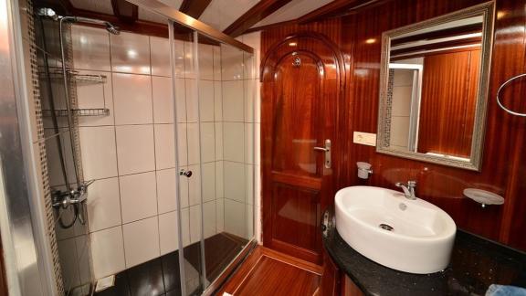 Stilvolles Badezimmer auf der Queen Lila, mit moderner Dusche und eleganter Holzverkleidung.