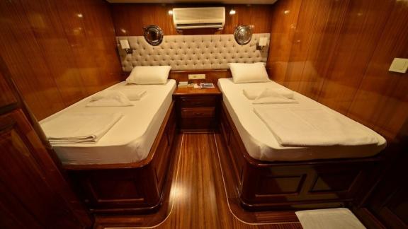 Twin cabin on the Queen Lila, with two single beds and elegant wood panelling.