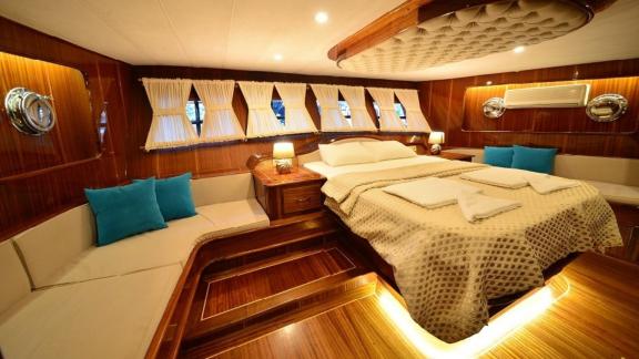 Spacious main cabin of the Queen Lila, with large windows and luxurious furnishings.