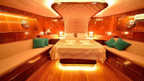 Luxurious cabin on the Queen Lila, with fine wood panelling and stylish lighting.