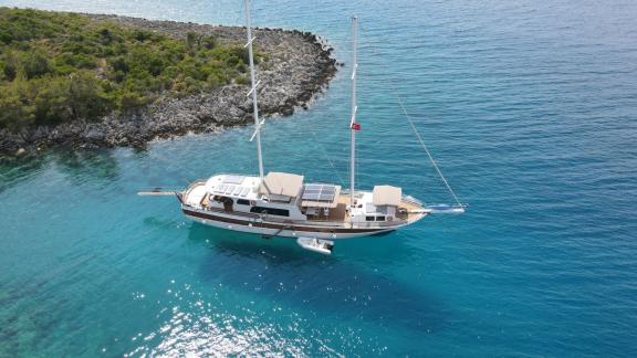 The Queen of RTT is anchored in the turquoise waters of Fethiye, surrounded by lush coastal scenery.