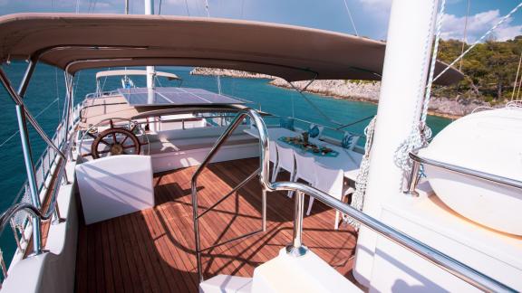 The upper deck of the gulet Queen of RTT in Fethiye has a sun deck, a steering position and a cosy dining area.