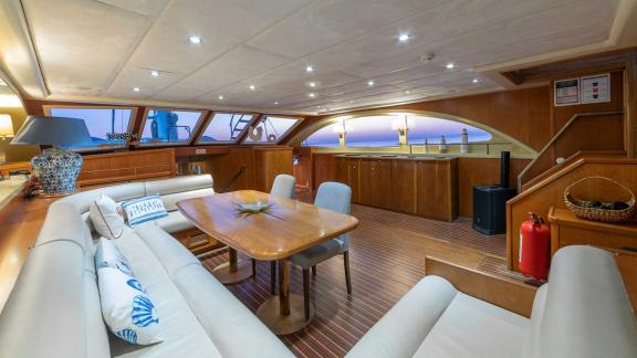 The elegant saloon of a Bodrum Gulet with 5 cabins, equipped with a comfortable seating area, a dining table and stylish