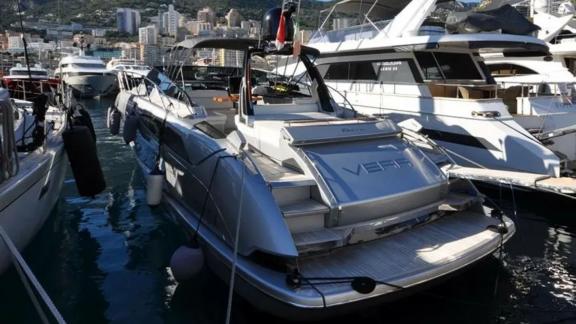 Среди вариантов посуточной аренды яхт в Монако Vera моторная яхта показана сзади у причала с платформой.
