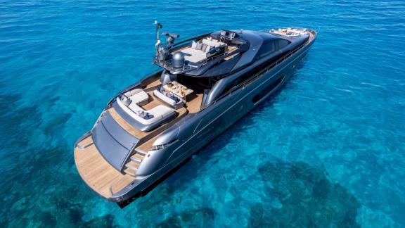 Die Tanit liegt vor Ibiza vor Anker und zeigt einen Flybridge Sitzbereich sowie ein großes Achterdeck.