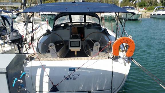 Das Achterdeck der Yacht Laertis mit zwei Steuerrädern, im Hafen vertäut an einem sonnigen Tag.