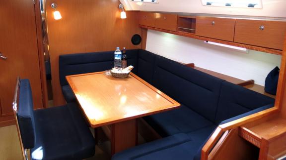 The interior seating area of sailing yacht Almina features a comfortable dining table and seating.