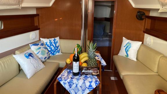 The saloon of the sailing yacht Çakıl offers a warm atmosphere with decorative pillows and a fruit basket.