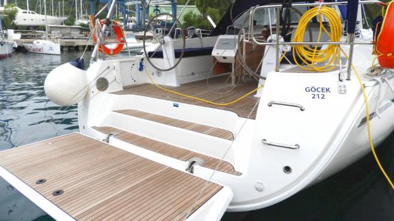 The wide aft deck of the Nanna sailing yacht is seen docked in Göcek harbor.