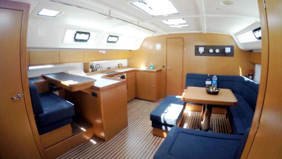 The saloon of the sailing yacht Nanna offers comfort with a modern kitchen and cozy seating arrangement.