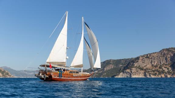 Elegante 24 Meter Gulet Yüce Bey segelt majestätisch vor der atemberaubenden Küste von Marmaris, Türkei.