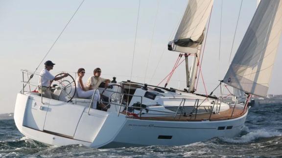 The Mercann sailing yacht sails swiftly with wind-filled sails as the crew enjoys the journey at sea.