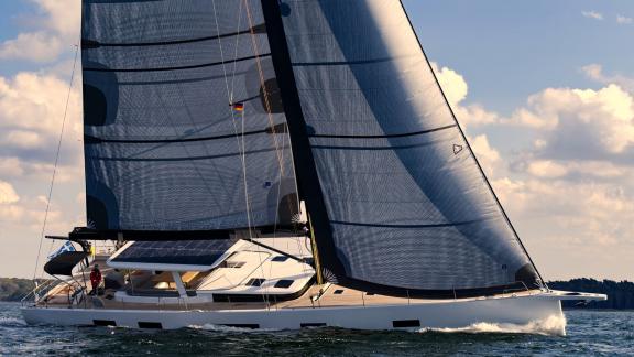 The luxury sailing yacht Nadamas elegantly sails with wind-filled sails over the sea.