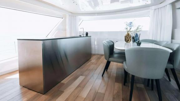 The dining and bar area on motor yacht Coco De Mer features stylish minimalist decor and expansive sea views.