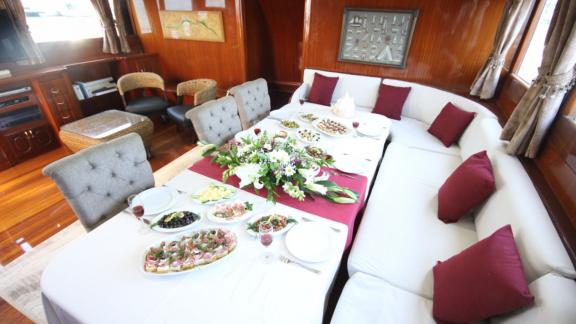 Comfortable saloon of the Diamond Lila with inviting dining area, stylishly laid table and elegant interior design.