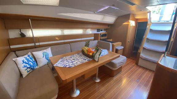 The interior of the sailing yacht Pherusa II offers a comfortable seating area and dining table.