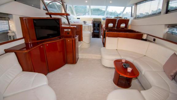 Elegant salon of motor yacht NateWhite with spacious seating area and TV.