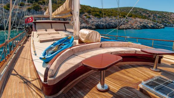 The spacious deck of the 24-meter Gulet Sani Kaptan 2 with comfortable sunbathing areas and a kayak in Bodrum, Turkey.