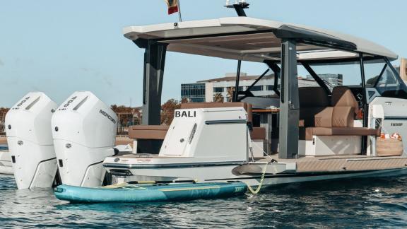 The aft deck of motor yacht Bali features a paddleboard and powerful twin engines for water sports.