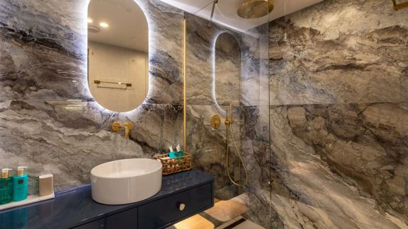 Scorpios Motorsailer features marble walls, a glass shower area and an elegant sink unit.