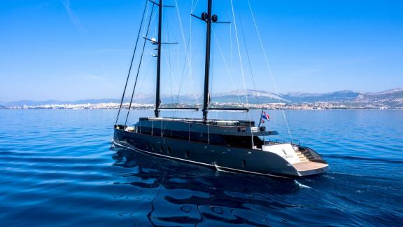 Among Split yacht charter options the 6 cabin 12 guest Scorpios motorsailer seen from stern while cruising at sea.