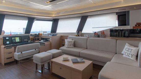 The stylish living area of the Serenissima catamaran with sofa and control panels.