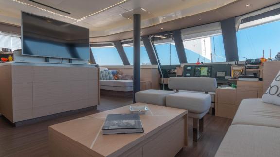 Spacious living area on the Serenissima catamaran with TV and comfortable seating.