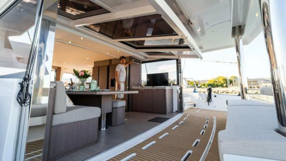 View of the open living area on a Bali catamaran, featuring a dining area and cozy seating that connects indoor and outd