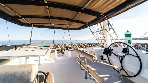 The helm area of a Bali catamaran with comfortable seating, overlooking the sea and harbor.