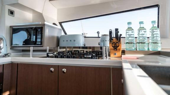 Bright, modern kitchen with SMEG appliances, a gas stove, and water bottles on a Bali Catamaran.